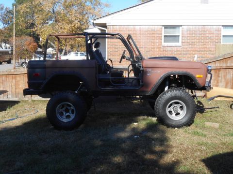 1972 Ford Bronco - This 1972 Ford Bronco, seen in a side profile, features a roll cage and lifted suspension, appearing to be in a state of restoration.