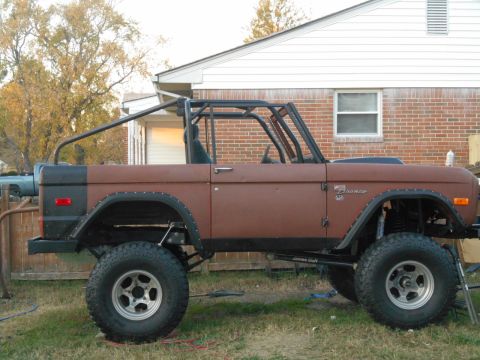 1972 Ford Bronco - Side view of a lifted 1972 Ford Bronco with a custom roll cage and aftermarket wheels.