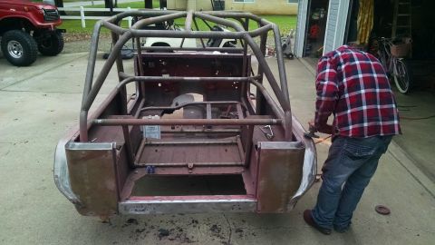 1985 Jeep CJ7 - Fabrication work on a 1985 Jeep CJ7 body, a custom roll cage. Another vehicle is visible in the background.