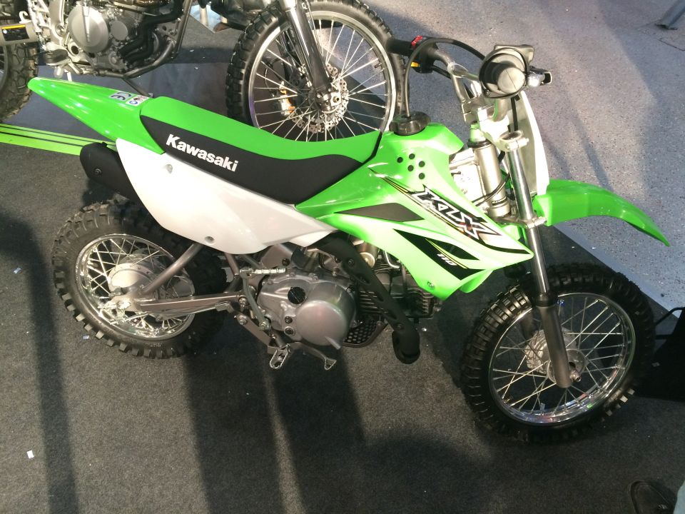 Green Kawasaki dirt bike with KLX graphics. Another dirt bike is partially visible behind it