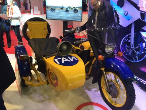 1987 Ford Bronco - A vintage yellow and blue motorcycle with a sidecar is displayed, showing a prominent siren and Cyrillic lettering on its body.