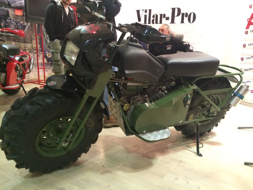 Green all-terrain motorcycle with huge tires and a black fairing