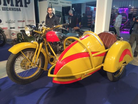 1987 Ford Bronco - A yellow motorcycle with a sidecar is displayed indoors, possibly at a show.
