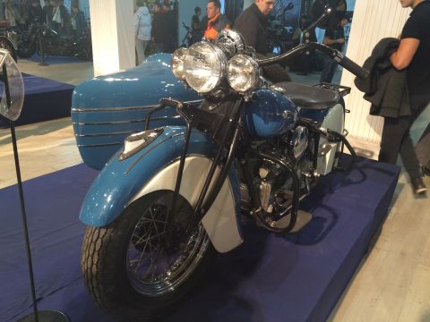 1987 Ford Bronco - A vintage motorcycle with a sidecar is displayed on a blue platform.