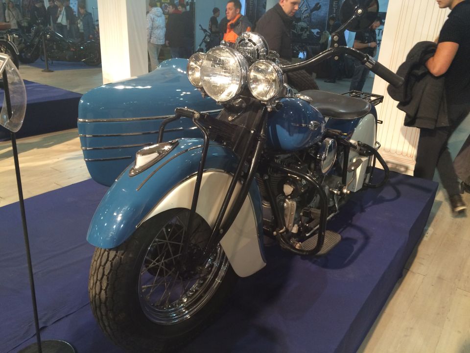 Blue and silver motorcycle with a matching sidecar, viewed from the front three-quarter angle