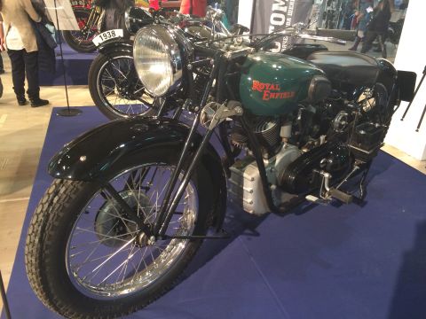 1987 Ford Bronco - A 1938 Royal Enfield motorcycle is displayed indoors, with another vintage motorcycle visible behind it.