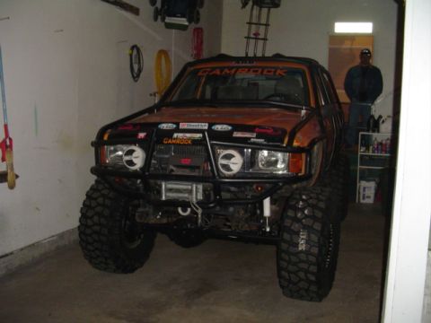 1993 Ford Bronco - Modified SUV with off-road tires and a custom bumper sits in a garage.