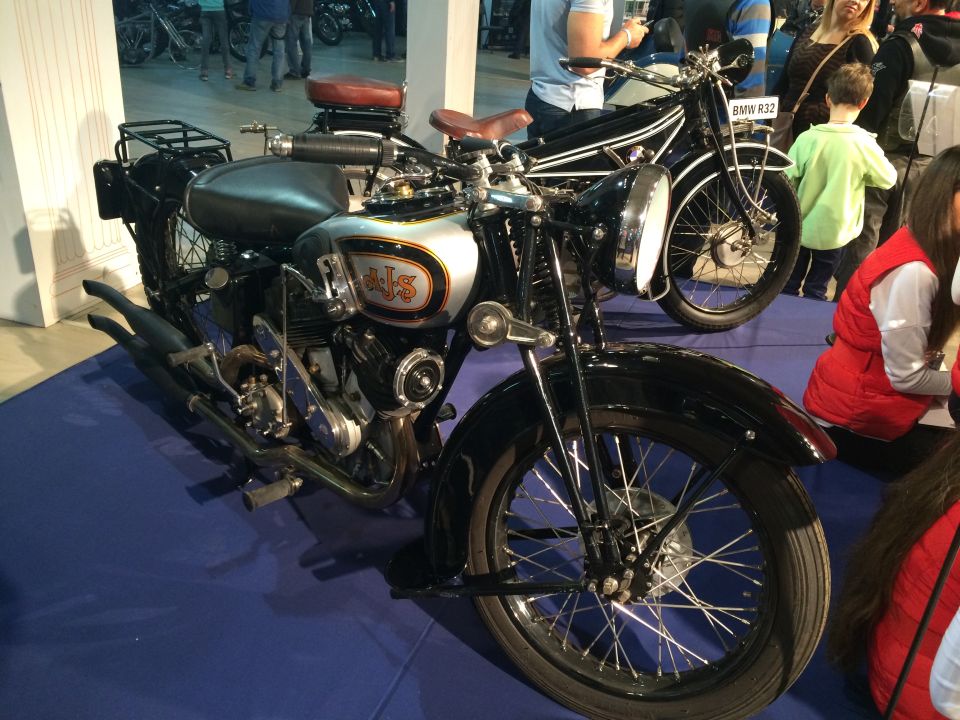 Vintage black and silver motorcycle with a spoked front wheel and silver fuel tank.