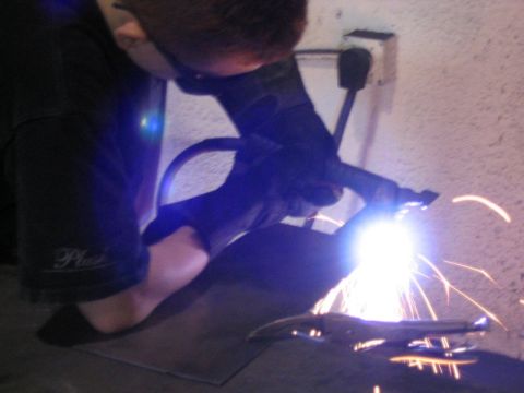 1993 Ford Bronco - Sparks fly as a person welds a metal object in a workshop.