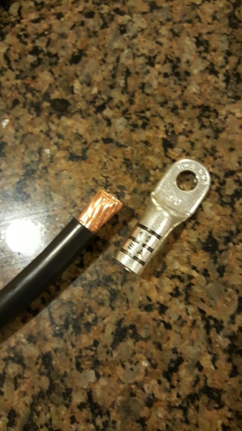 1996 Ford Bronco - A close-up shot shows the exposed copper strands of a black electrical wire next to a silver electrical lug with black markings. The items…