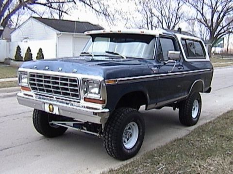 1995 Ford Bronco - This lifted Ford Bronco features a prominent grille and a two-tone paint scheme.