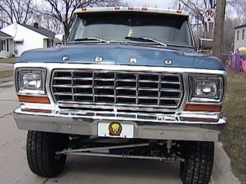 1995 Ford Bronco - Front view of a blue Ford truck, likely from the late 1970s, a prominent chrome grille and orange marker lights.