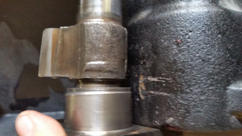 Close-up of a hexagonal nut on a metal part next to a textured black housing.