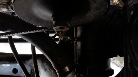 1979 Ford Bronco - A close-up view shows a black rubber hose connected to a metal fitting on a black component, likely part of a vehicle's engine or power ste…