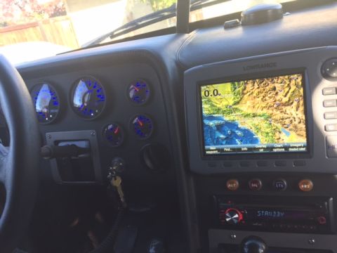 1986 Ford Bronco - The interior dashboard of a vehicle features a Lowrance GPS unit displaying a map of California, surrounded by multiple gauges and a car st…