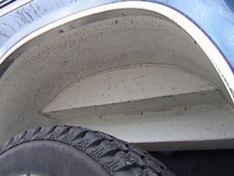 1995 Ford Bronco - Close-up view of the rear wheel well on a blue 1995 Ford Bronco.