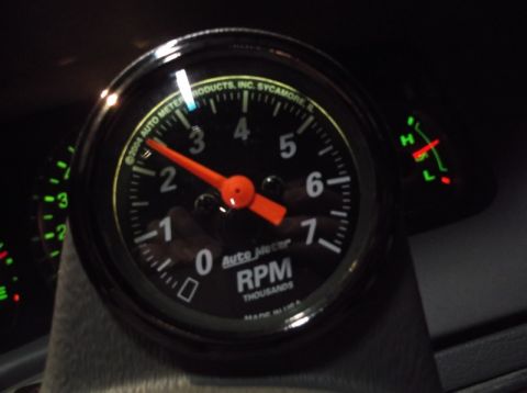 1999 Mercury Grand Marquis - A close-up shot of a car's dashboard shows a tachometer with an orange needle pointing slightly past the 2 mark, indicating RPMs in the tho…