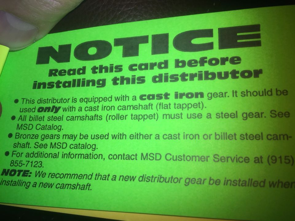 Green card with black text notice about installing a distributor.
