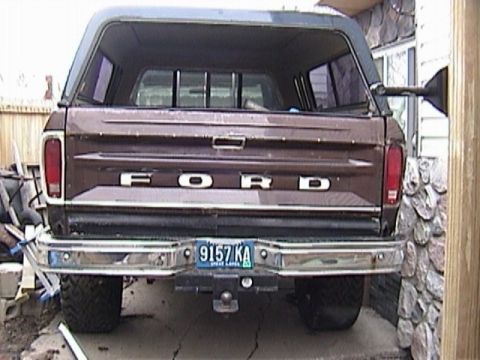 1995 Ford Bronco - This Ford pickup truck features a camper shell and a chrome bumper. The license plate is visible.