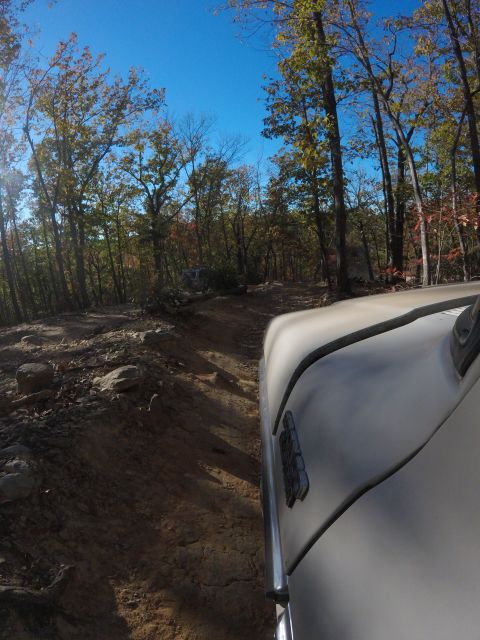 1979 Ford Bronco - A tan 1979 Ford Bronco drives down a dirt trail in a forest during autumn. The camera is mounted to the front passenger side of the vehicle…