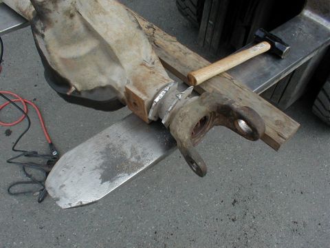 1983 Ford Bronco - Close-up of an axle tube end and knuckle C being set up for welding, with the joint wrapped in aluminum tape and squared against a wood blo…
