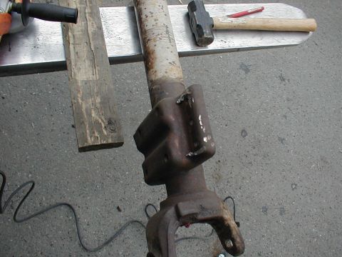 1983 Ford Bronco - Looking down a rusty axle tube at a cast spring perch and the knuckle C-end tacked in place, with chalk lines and tack welds marking the se…