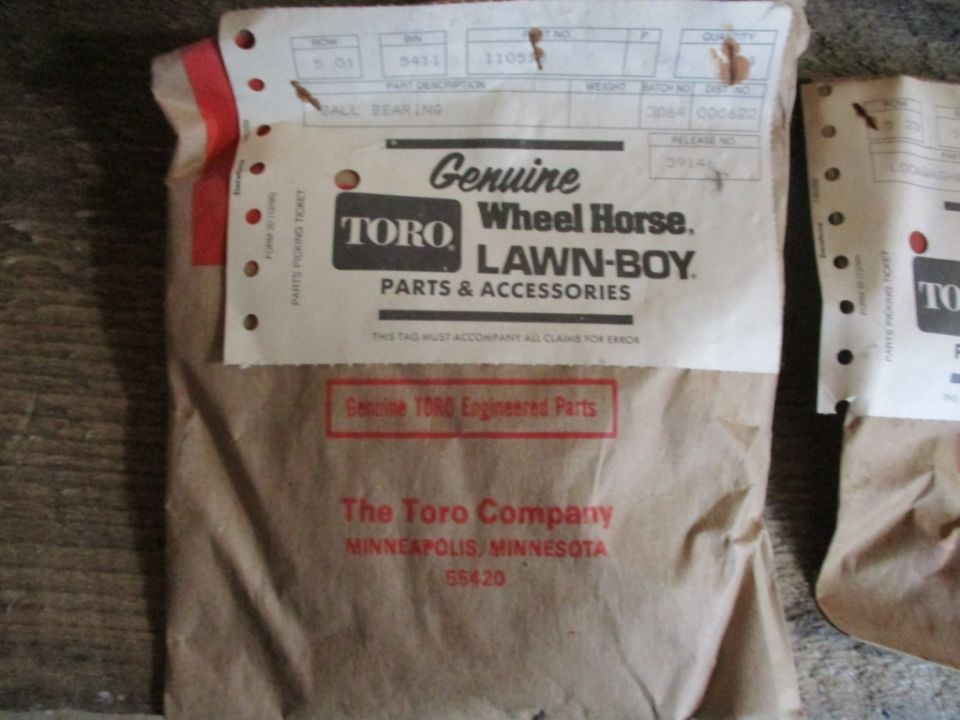 Two brown paper packages with Toro Wheel Horse Lawn-Boy parts and accessories labels. One label says "Genuine Toro Engineered Parts"