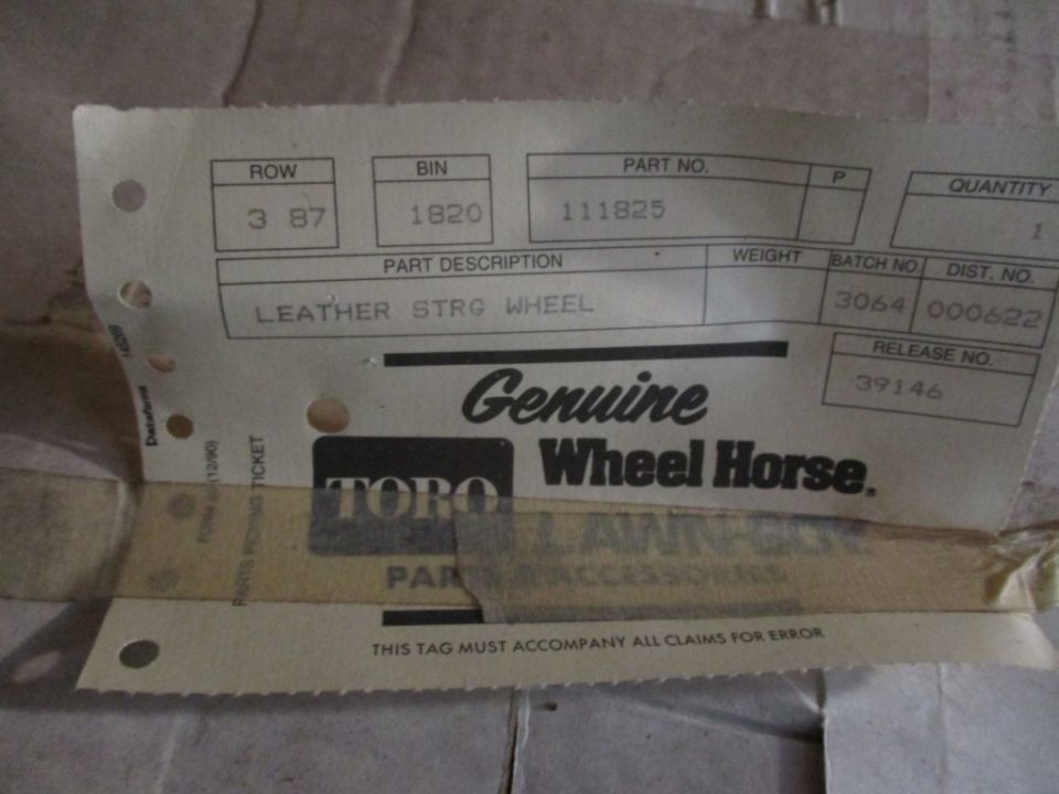 Part tag for Toro Wheel Horse showing ROW 3 87, BIN 1920, PART NO. 111825, and description LEATHER STRG WHEEL