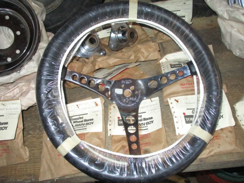Chrome steering wheel with black grip, wrapped in plastic, with "Genuine Wheel Horse Lawn-Boy Accessories" packaging