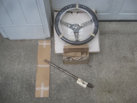 1986 Yamaha BLASTER - A steering wheel and shaft are laid out on a concrete surface with packaging materials, suggesting they are parts for sale or storage.