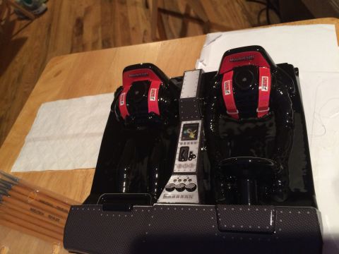 1989 Ford Bronco - A close-up view of a black racing simulator cockpit, complete with red racing harnesses and a detailed control panel.