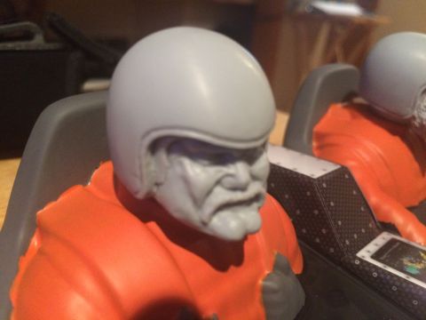 1989 Ford Bronco - Close-up of model figures wearing orange suits and helmets, suggesting a racing or pilot theme.