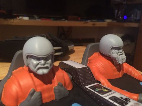 1989 Ford Bronco - Model figures with helmets and racing suits are positioned in a cockpit-like setting.