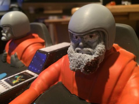 1989 Ford Bronco - Close-up of toy astronaut figures with detailed beards and helmets inside a cockpit setting.