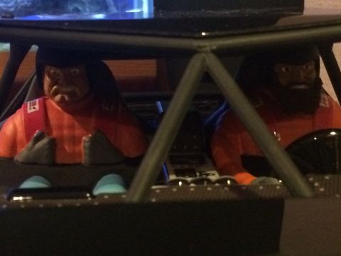 1989 Ford Bronco - The interior of a toy vehicle shows two figures in orange racing suits, suggesting a model or playset.