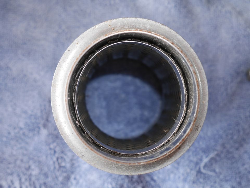 Interior of a metal exhaust pipe with a perforated lining.