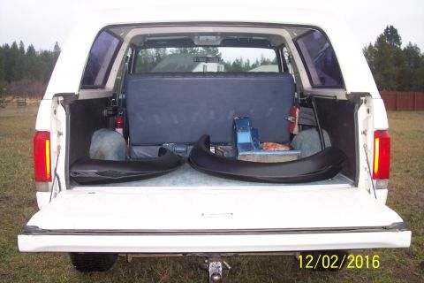 1990 Ford Bronco - Rear view of a 1990 Ford Bronco's interior, loaded with parts and equipment.