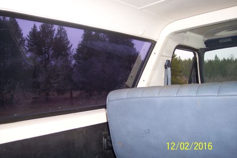 1990 Ford Bronco - Interior view of a vehicle showing a blue upholstered seat and a window with a view of trees. A date stamp reads "12/02/2016".