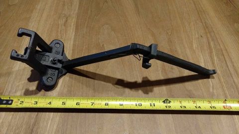 1971 Ford Ranchero - A black metal tool, possibly a jack handle or similar automotive part, is shown on a wooden surface next to a yellow measuring tape. The to…