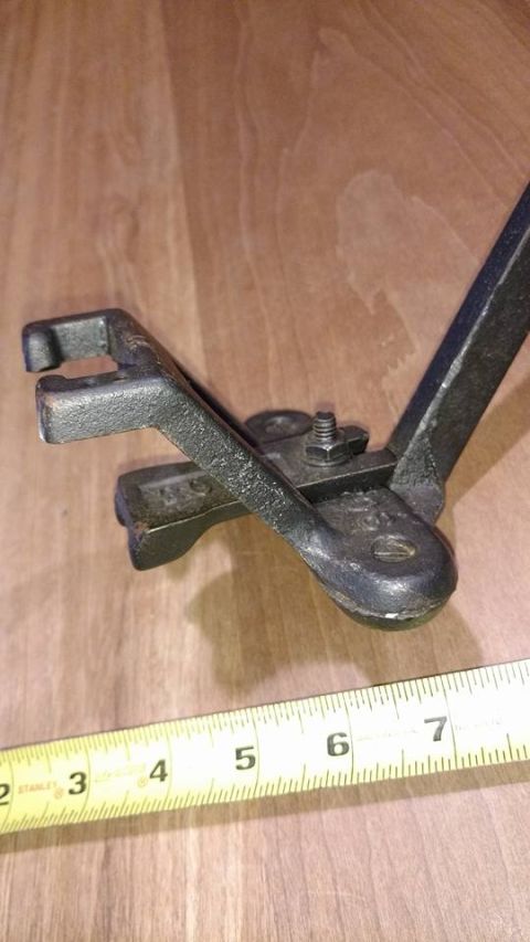 1971 Ford Ranchero - A close-up shot of a metal clamp or vise-grip tool resting on a wooden surface next to a yellow measuring tape.