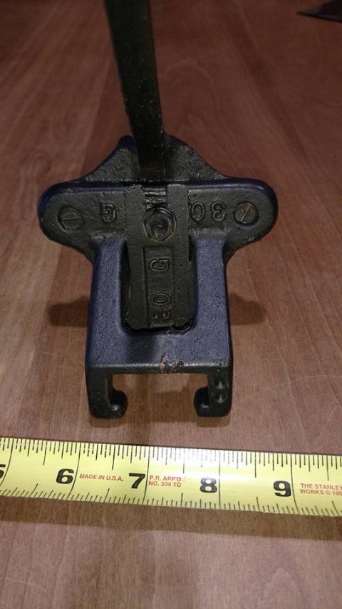 1971 Ford Ranchero - A close-up view of a metal clamp with "30 G" and "30" embossed on it, resting on a yellow measuring tape. The measuring tape shows markings…