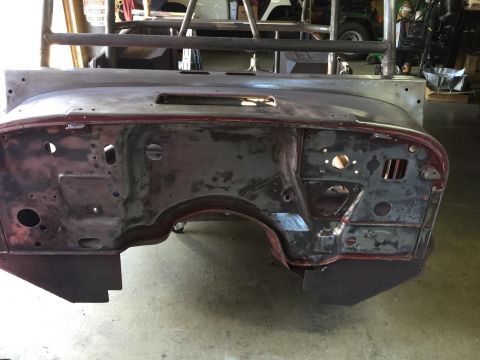 1985 Jeep CJ7 - This is a close-up, front-facing view of the firewall and inner fender area of a vehicle undergoing restoration. The metal is bare in many…
