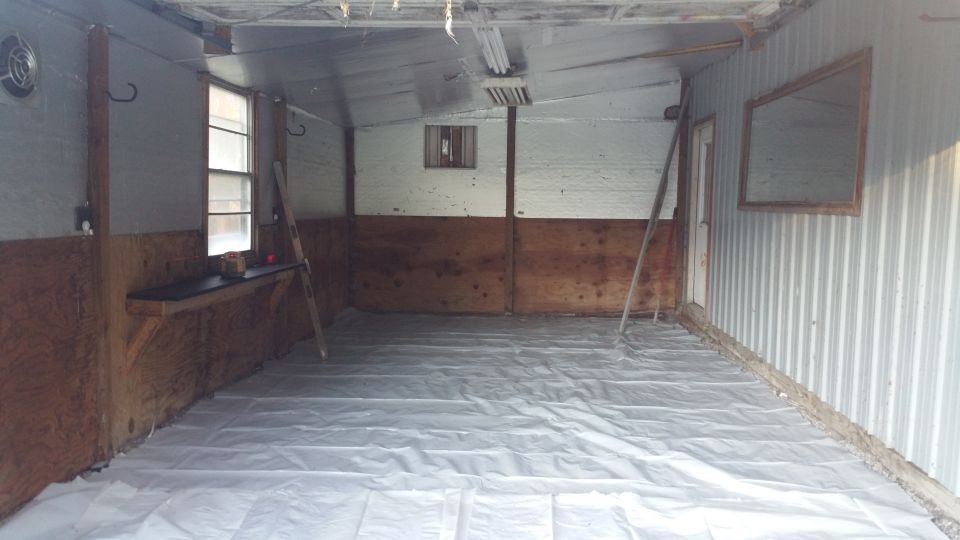 Interior of a workshop with plastic sheeting on the floor.