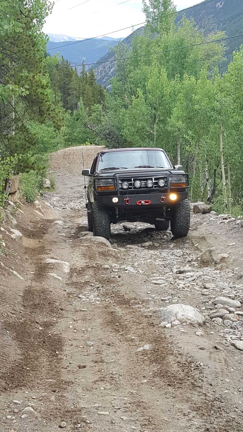 Black 1996 Ford Bronco on a rocky mountain trail.