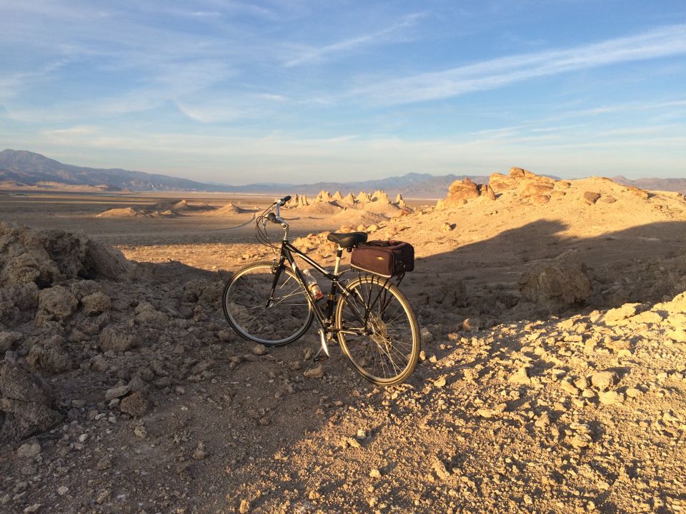 Bicycle parked in a desert landscape with tufa formations.