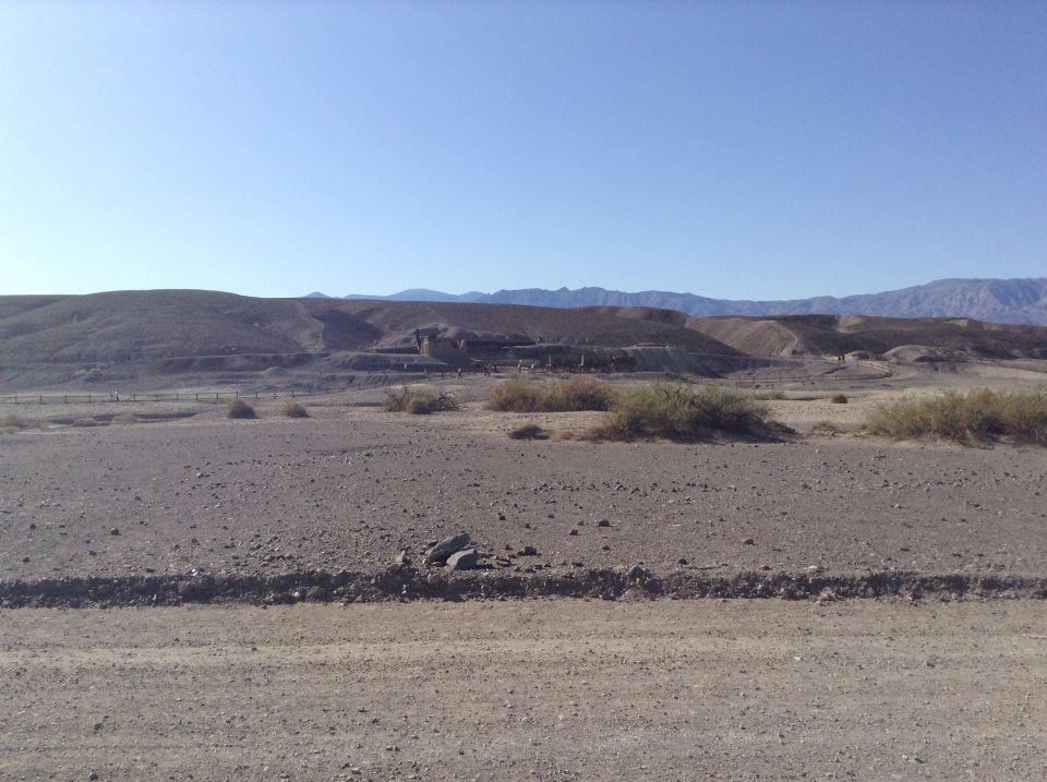 Arid landscape with ruins of structures on a hillside.