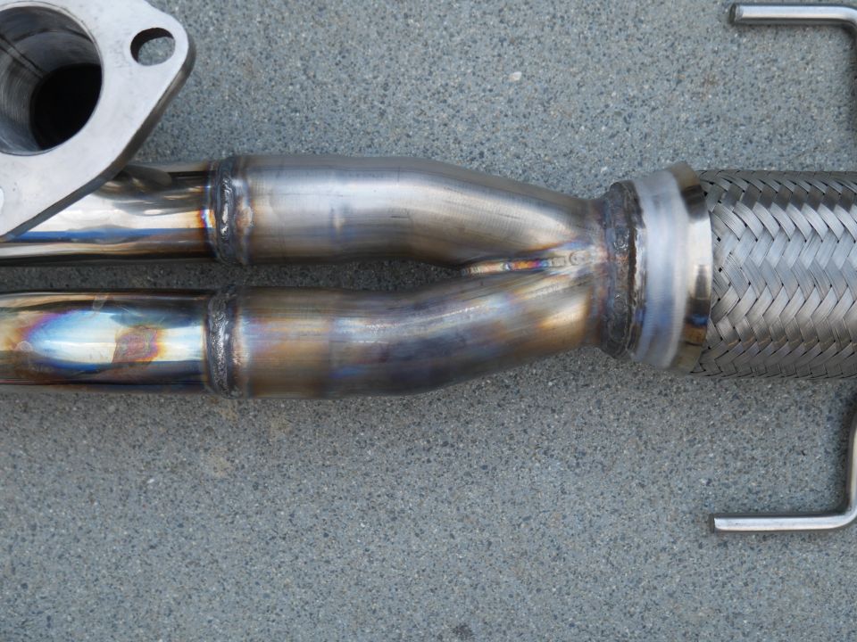 Exhaust Y-pipe with two inlets merging into one outlet, connected to a flexible pipe section
