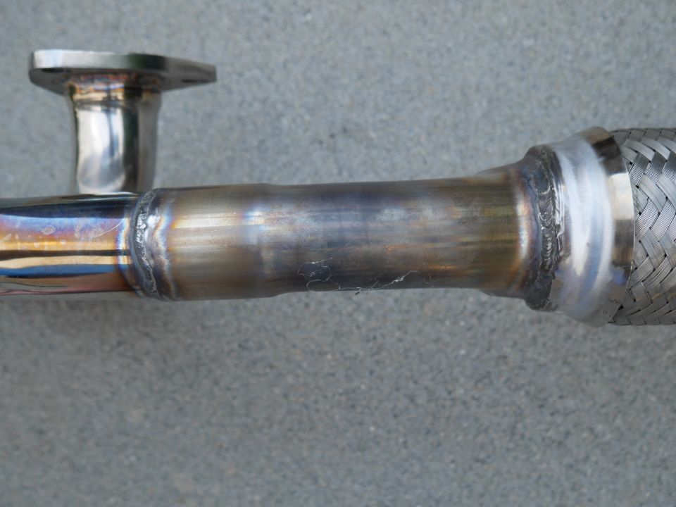 Exhaust flex pipe with a flange on one end and braided metal on the other, showing welds
