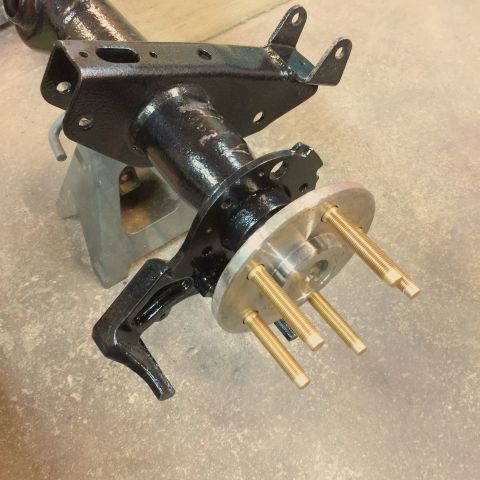 2004 Ford Crown Victoria - Rear axle assembly, likely for a Ford Crown Victoria, is shown on jack stands with new wheel studs installed.
