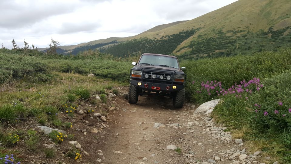 Black Ford Bronco on a dirt road in a mountainous landscape